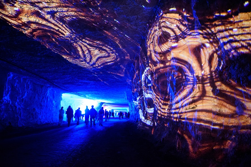 Image from Subsurface event showing attendees walking through mine with shapes projected on to the mine walls